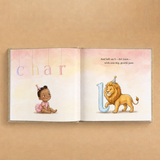 An open children's alphabet book laid flat on a warm beige background. The left page shows the letters 'char' in pastel colors above an illustration of a baby girl in a pink outfit.